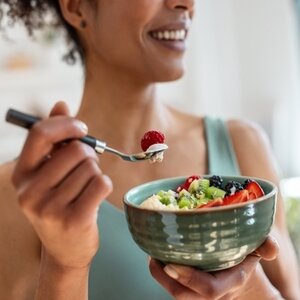 Woman eating a salad with a fork.